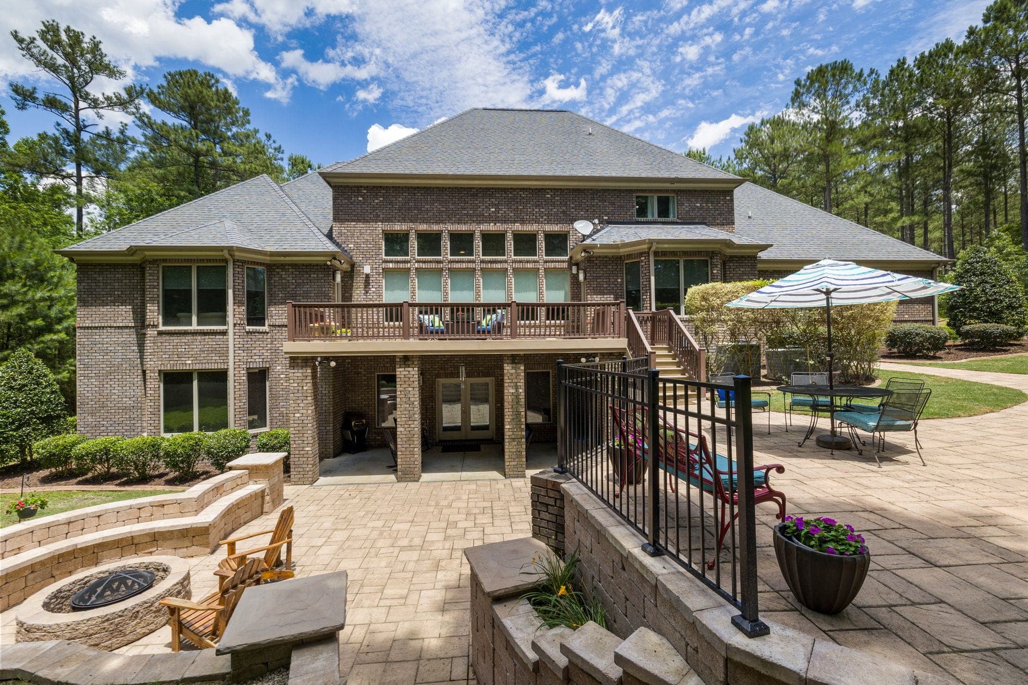 Paver patio with a stone fire pit and Adirondack chairs